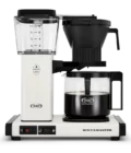 Front shot showing Moccamaster KBGV Select in Off-White, with rectangular tower and base, clear acrylic water reservoir with fill level marks, power and volume selector switch, glass carafe with black handle, and black automatic brew basket.